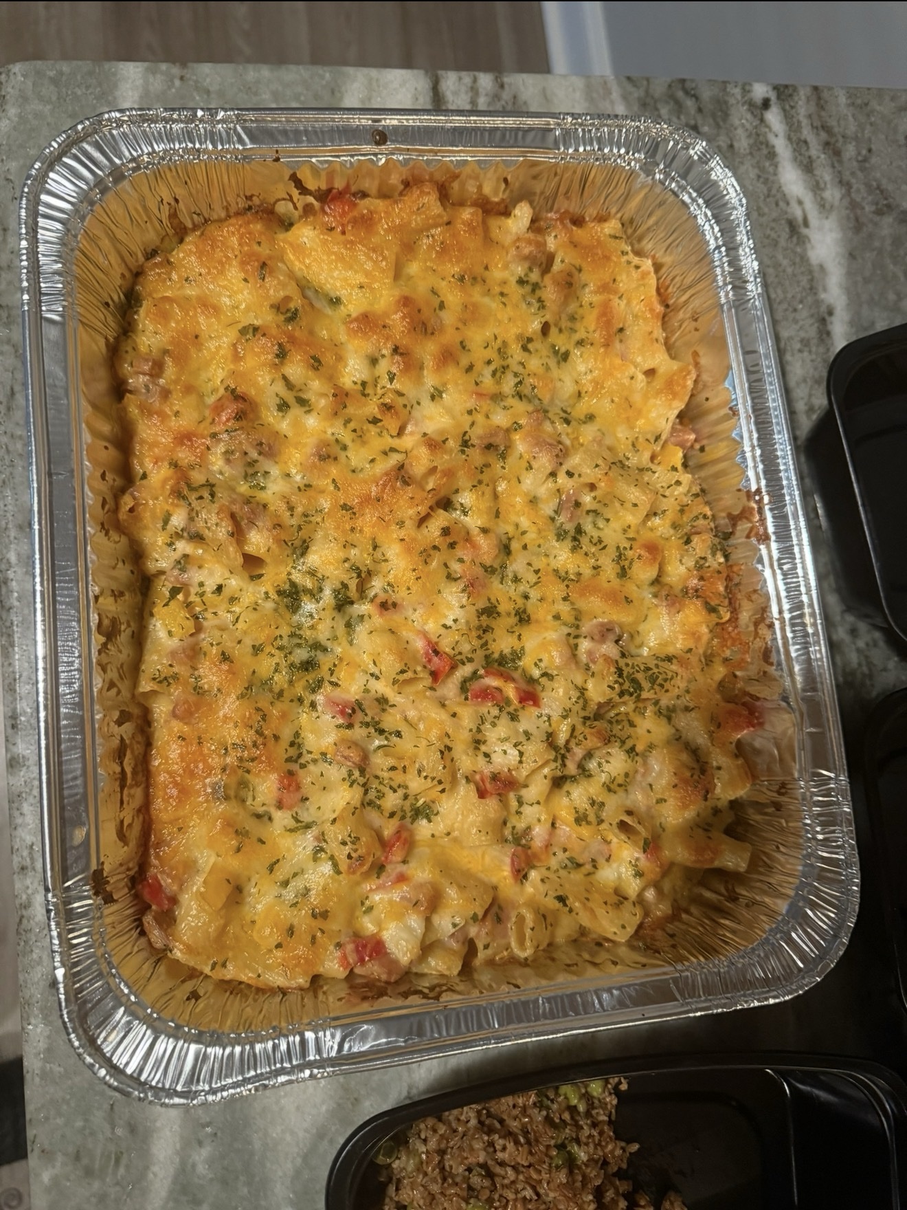 Creamy herbed baked pasta in a catering pan