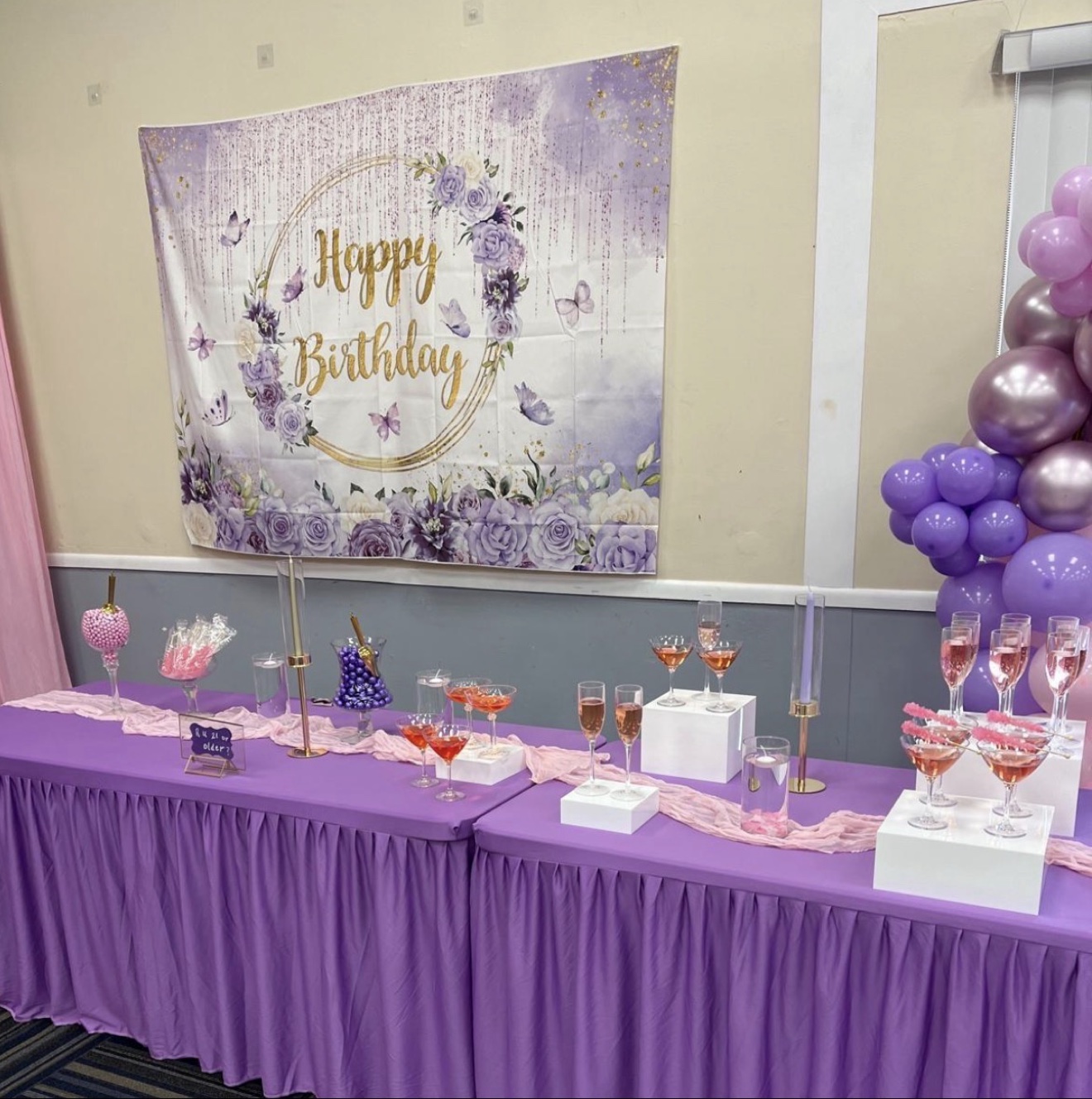 Purple birthday dessert table with balloon arch