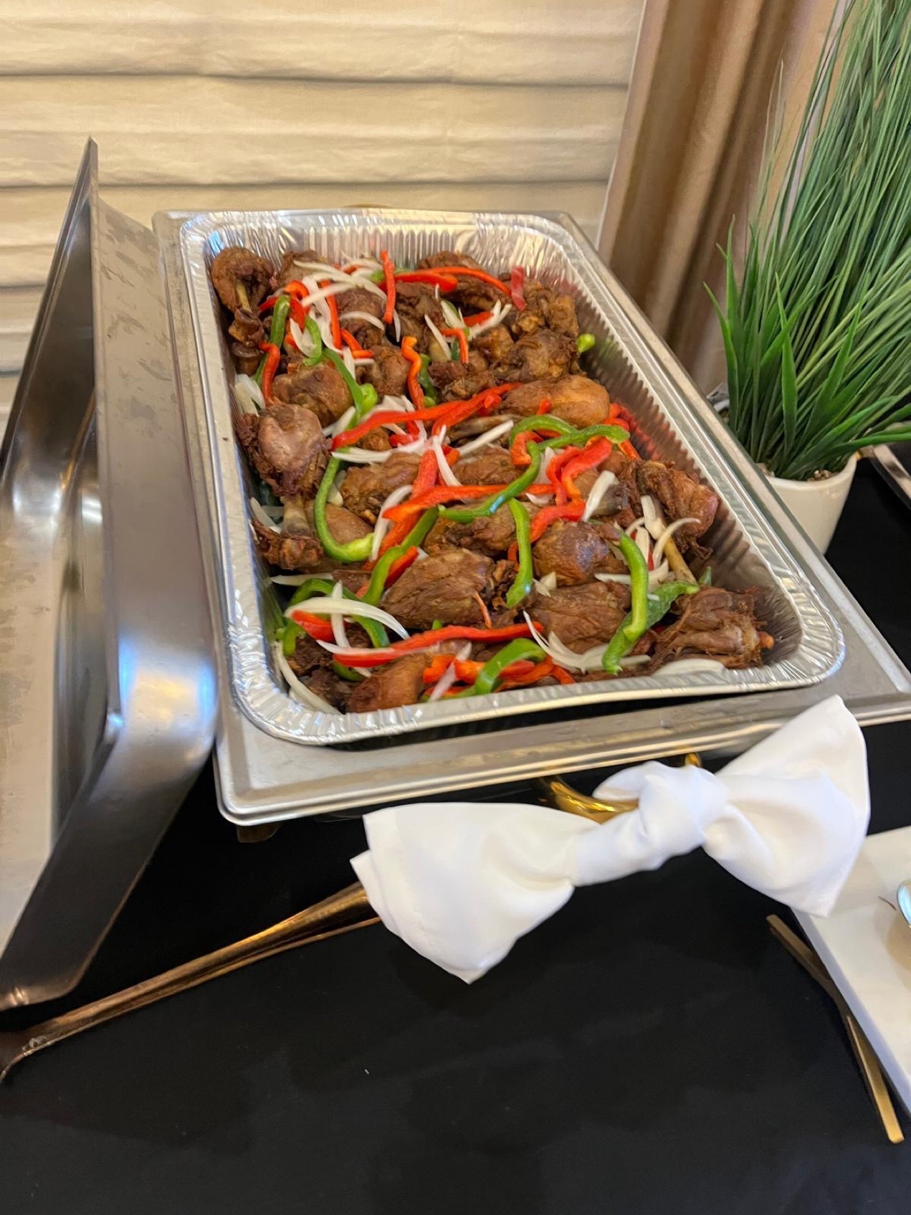 Brown stewed chicken topped with bell peppers and onions