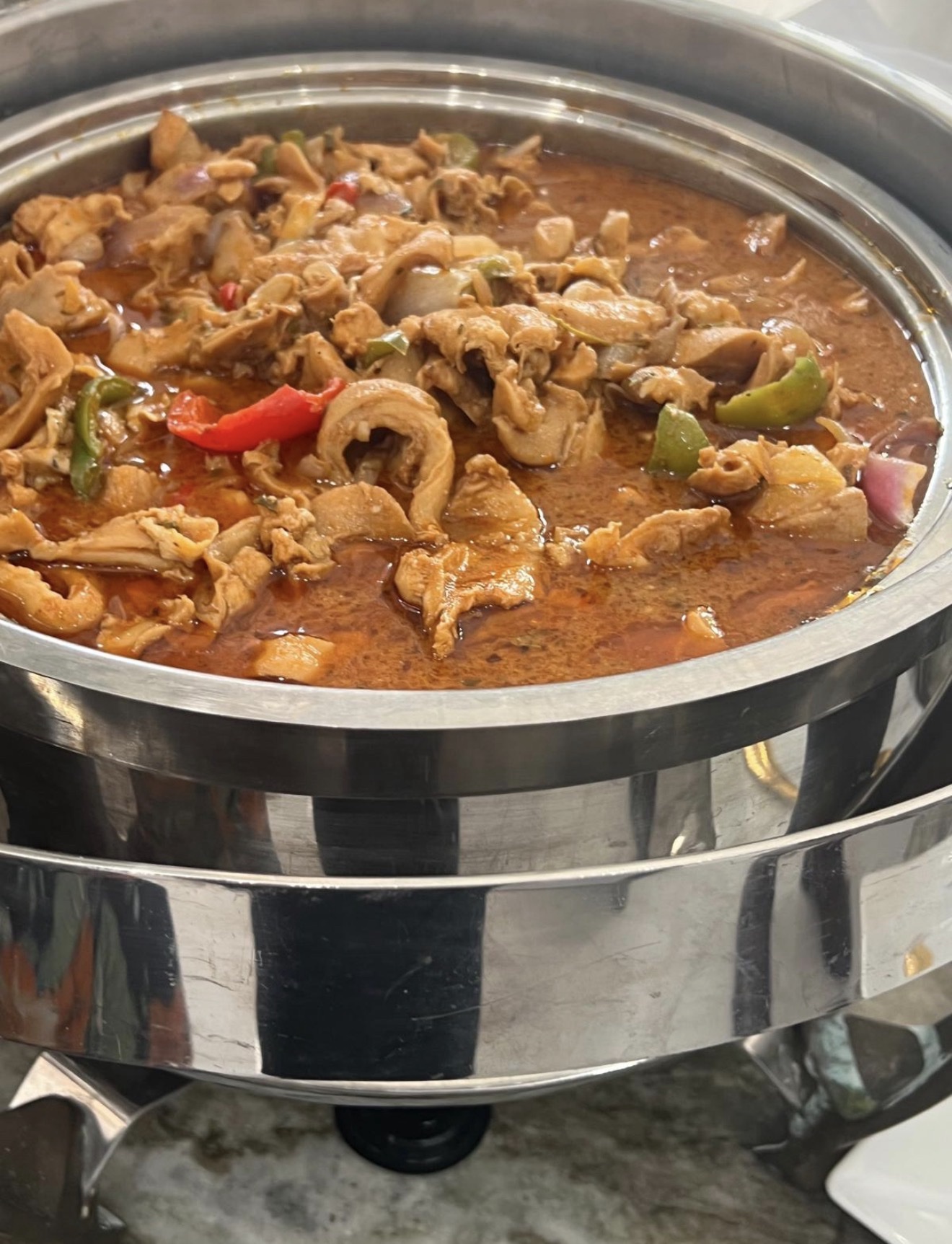 Stew conch with peppers and onions in a chafing dish