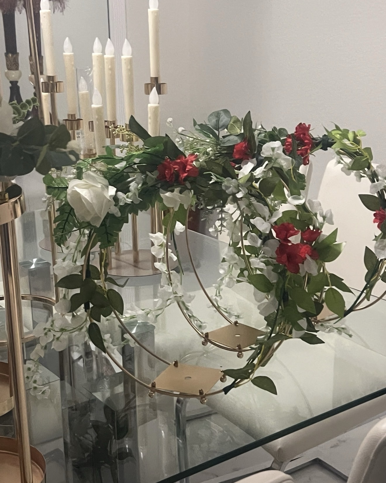White and green floral centerpiece surrounded by tall candles