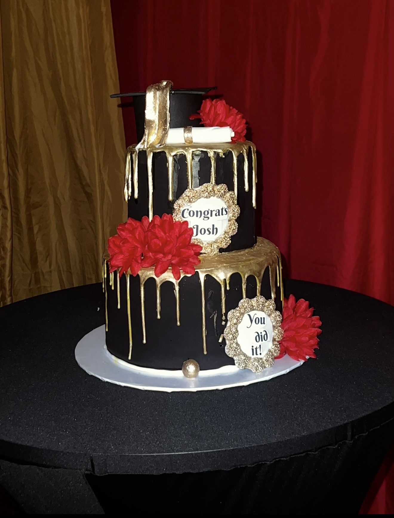 Black, gold and white graduation cake for Josh with red flowers