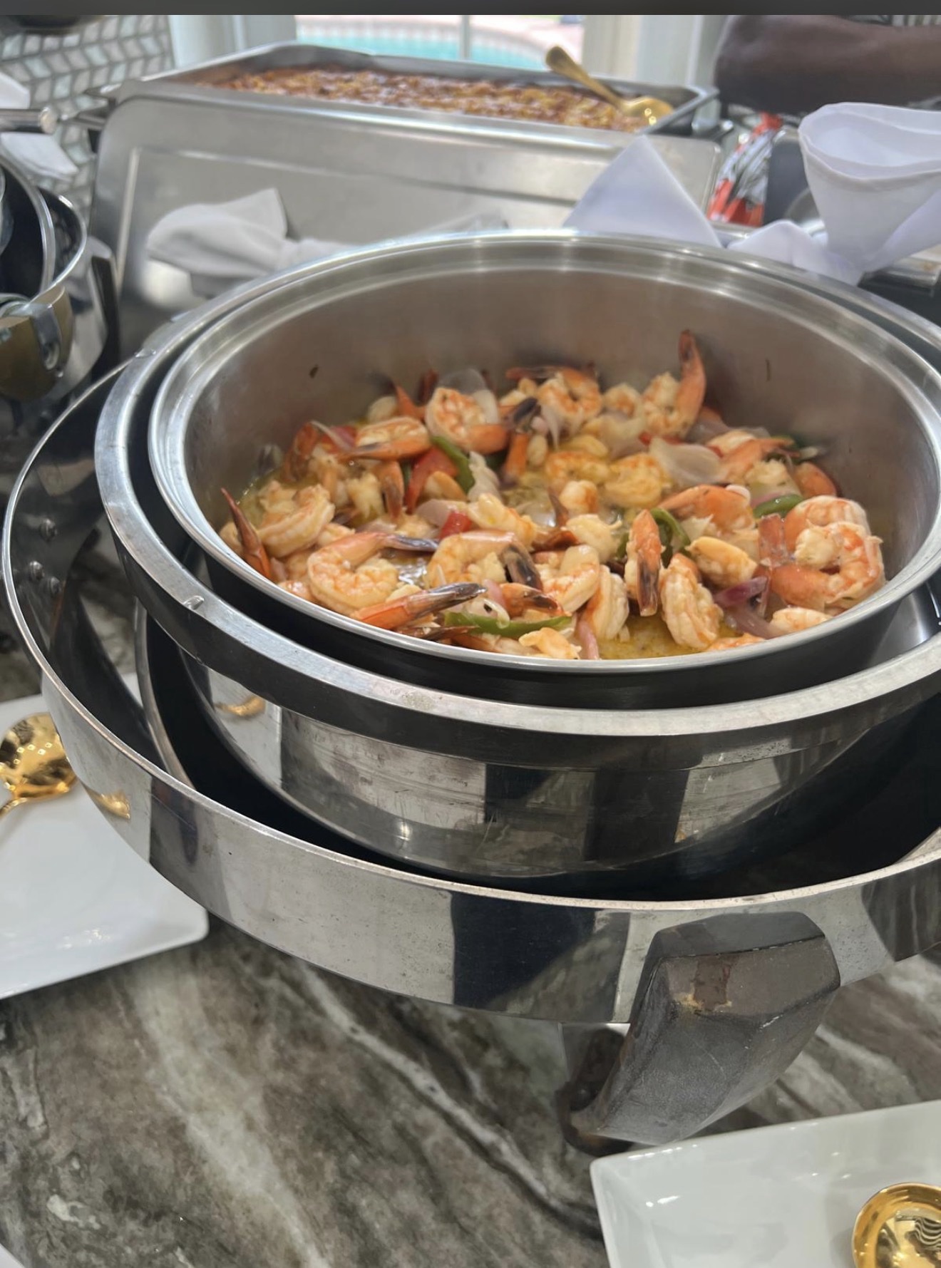 Sautéed shrimp with onions and peppers in a chafing dish