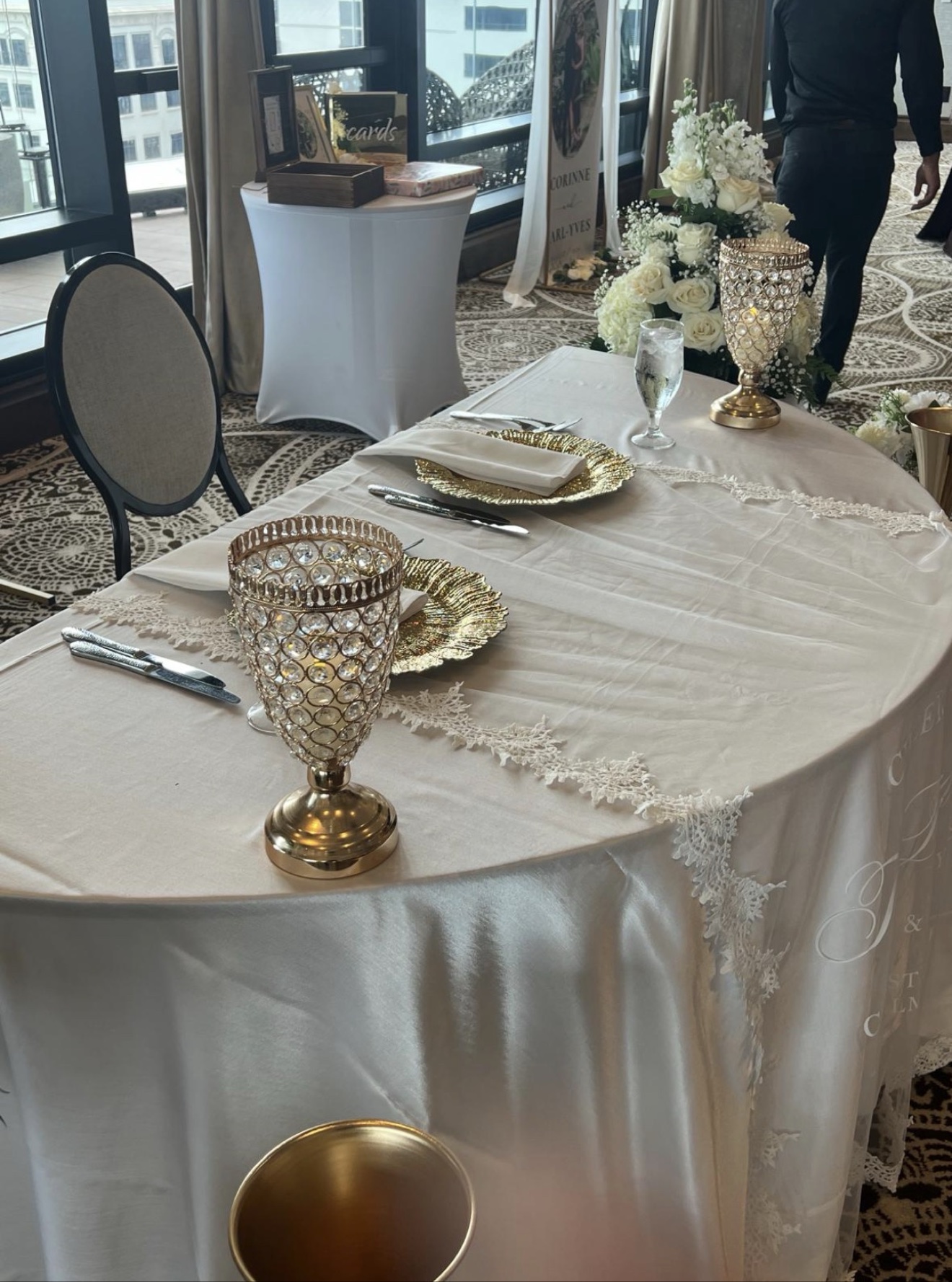 Sweetheart table with white roses, crystal goblets and gold chargers