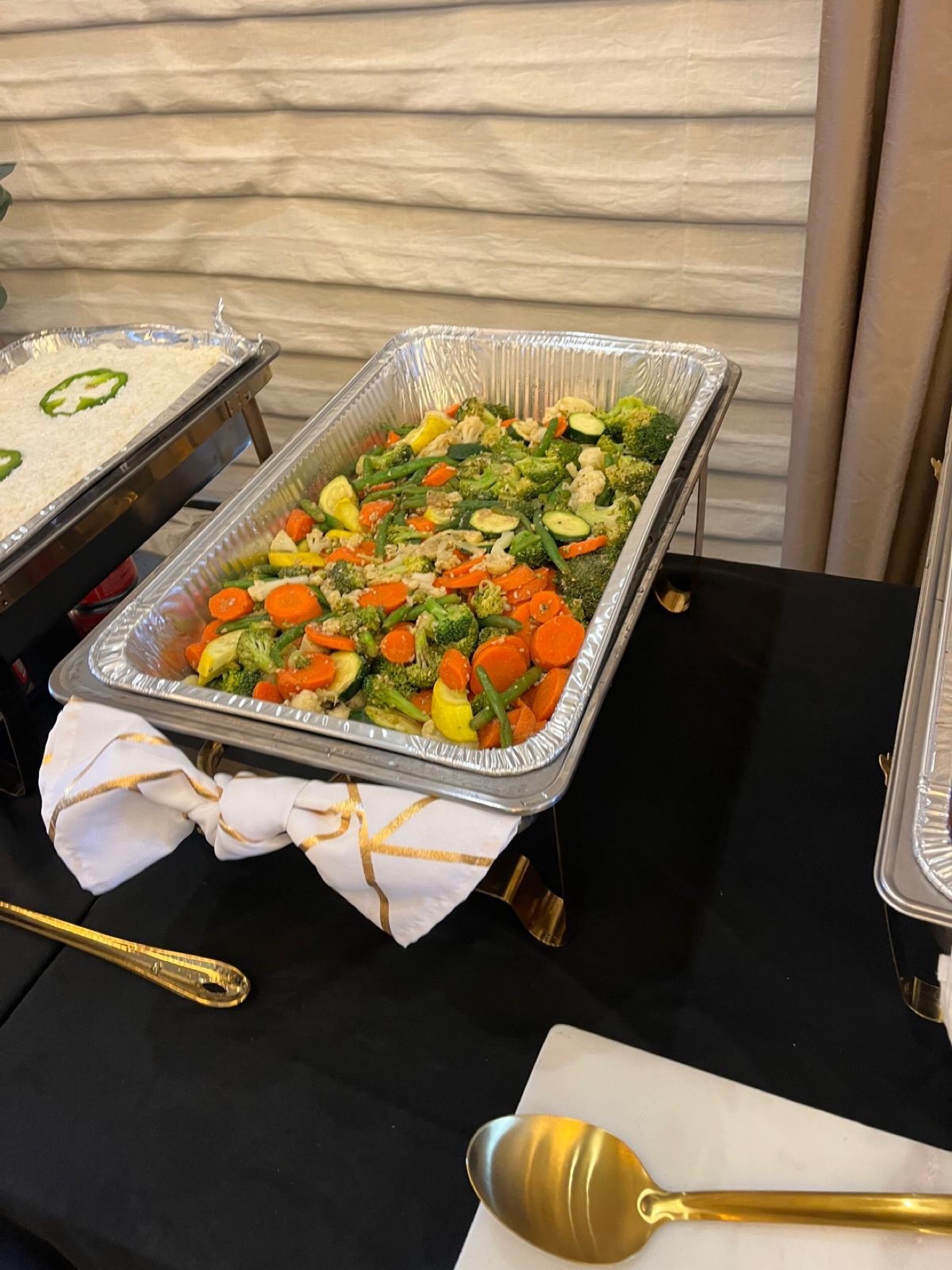Seasoned mixed vegetables and white rice in catering pans